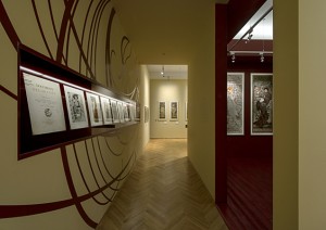 Stěna s vitrínou s grafickými listy z alba Documents Décoratifs. Zdroj: http://www.arn-studio.cz/